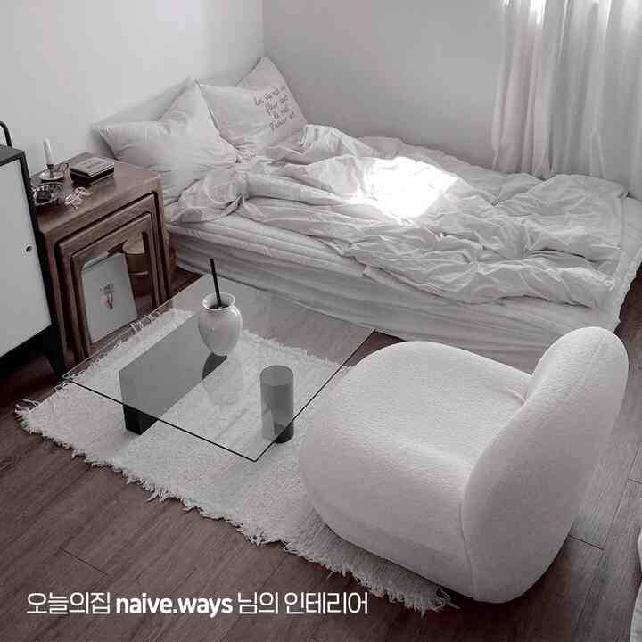 白と茶色のトーンのワンルーム寝室、シンプルでミッドセンチュリーモダンな家具が配置された落ち着いた空間