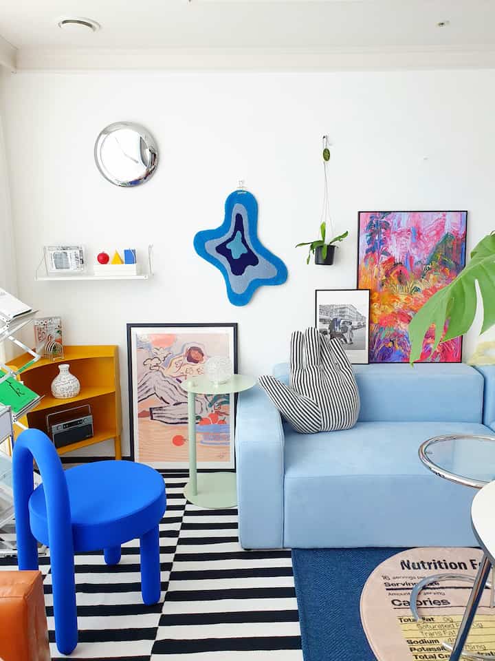 Bright white-walled modern living room featuring various blue-toned furniture in Mid-Century Modern style