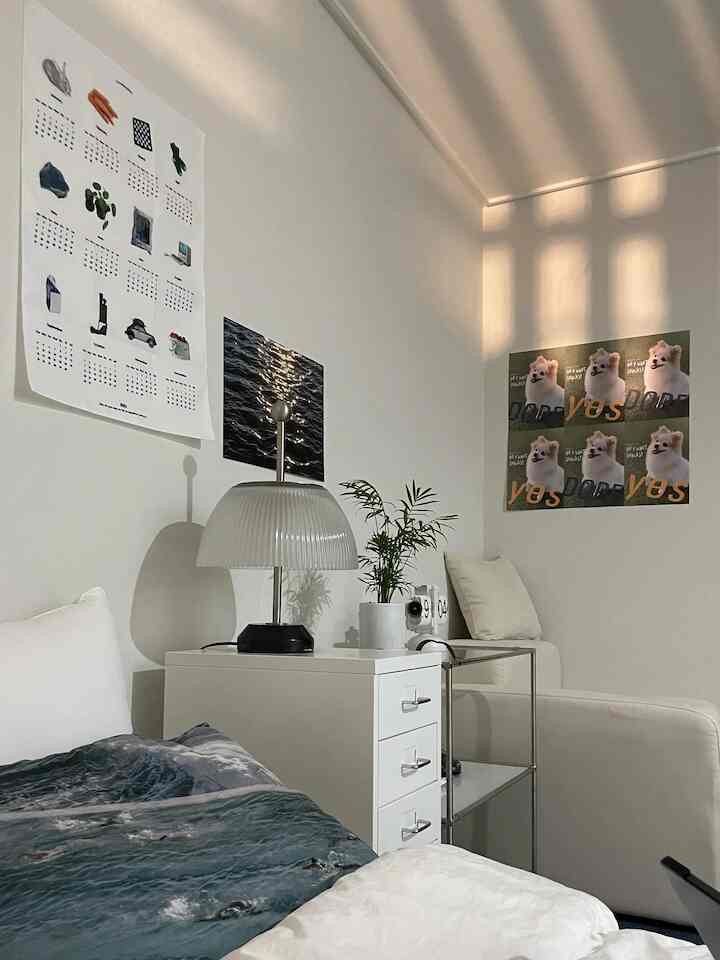 White and natural tone bedroom featuring a white dresser and armchair in a simple, minimalistic atmosphere
