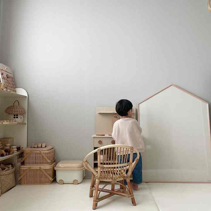 Natural-toned kids' room featuring wooden furniture and toy storage with a simple atmosphere