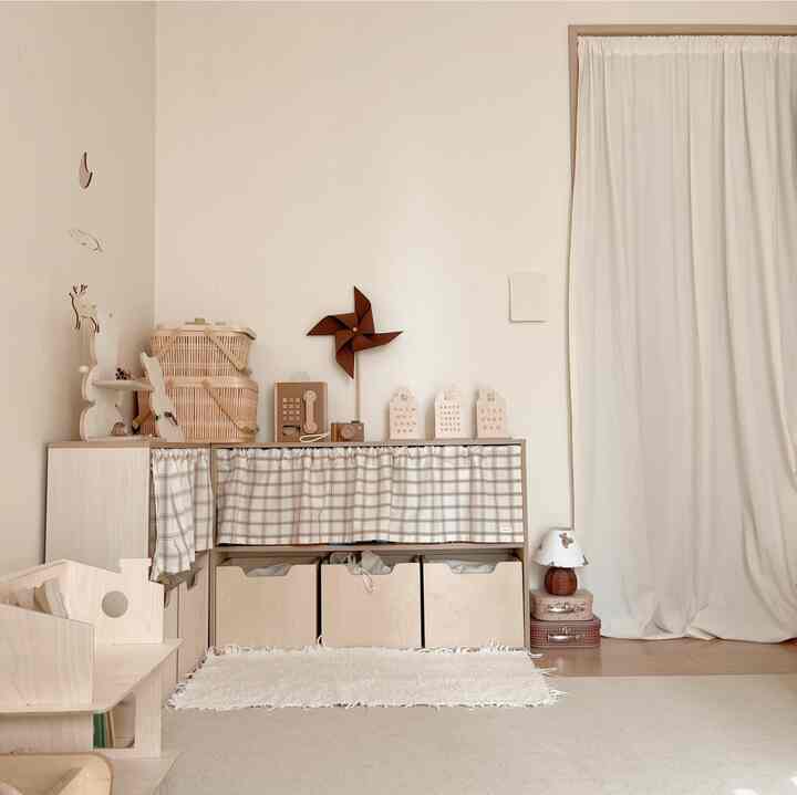 Bright wood-toned kids' room featuring toy storage with checked curtains and natural, tidy atmosphere