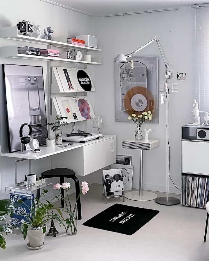 白を基調としたリビング、ミッドセンチュリーモダンの家具とフロアランプ、オーディオ機器、植物が調和した雰囲気のあるインテリア