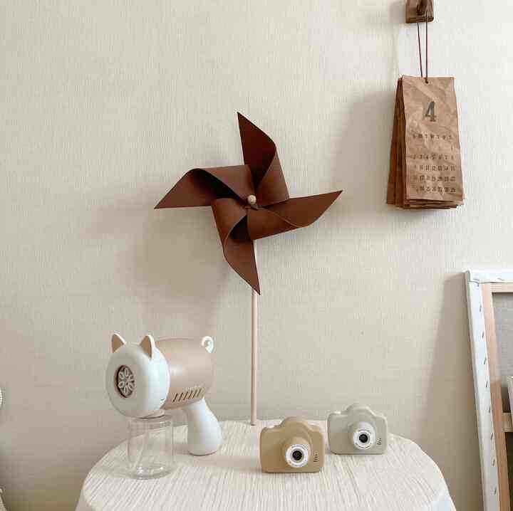 Beige and wood tone kids' room featuring baby bubble gun and toy cameras on a simple natural decor