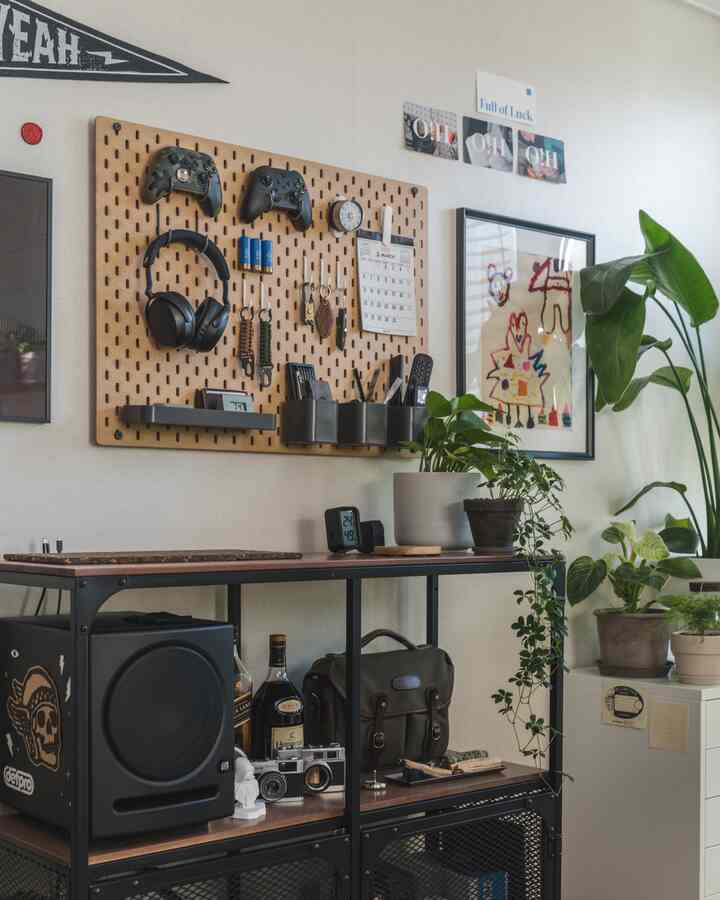 Natural-toned home office space with pegboard, shelving, and various plants creating a cozy atmosphere