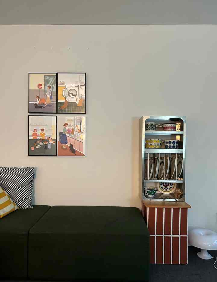 緑色のソファとヴィンテージの器が置かれたキッチン連携のリビング、シンプルでモダンな雰囲気