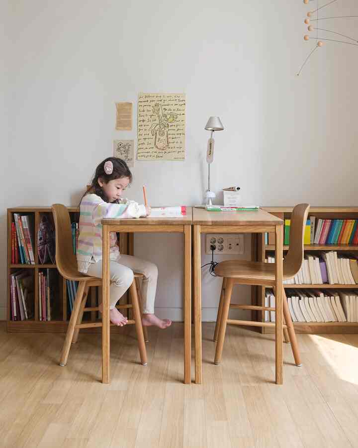 ナチュラルなウッドトーンの子供用書斎、木製の机と椅子、本棚が配置された落ち着いた清潔感のあるインテリア