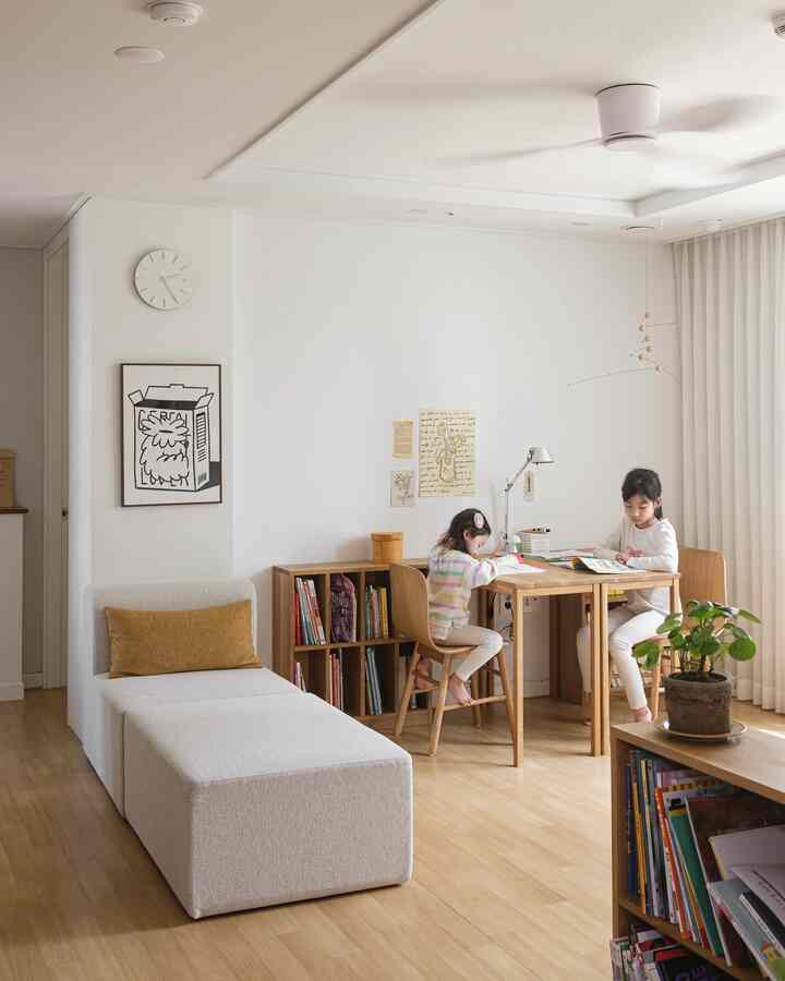 White and brown toned living room study featuring wooden desk and sofa in a simple natural setting