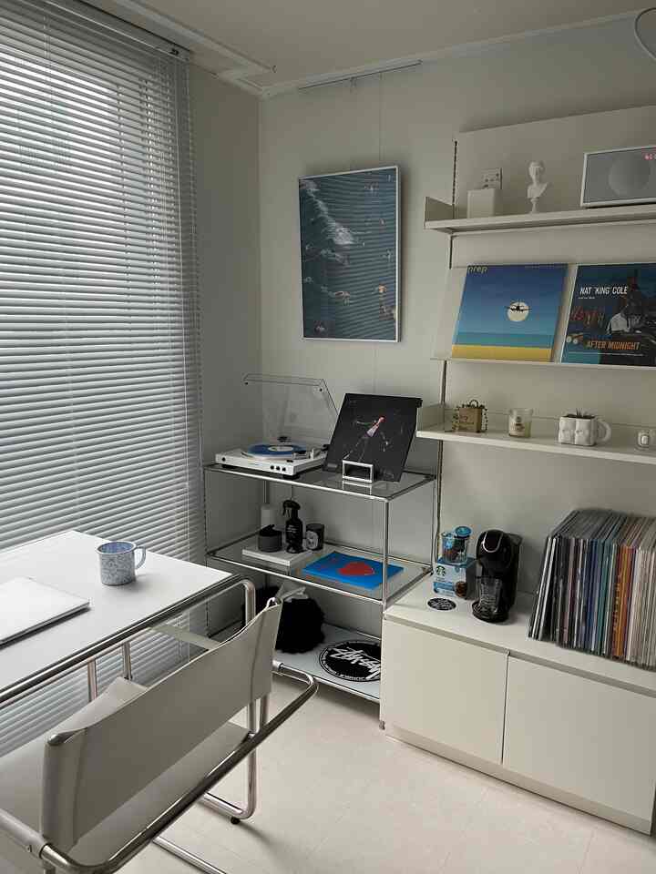 White-toned compact home office featuring a turntable and vinyl LPs creating a stylish music listening atmosphere