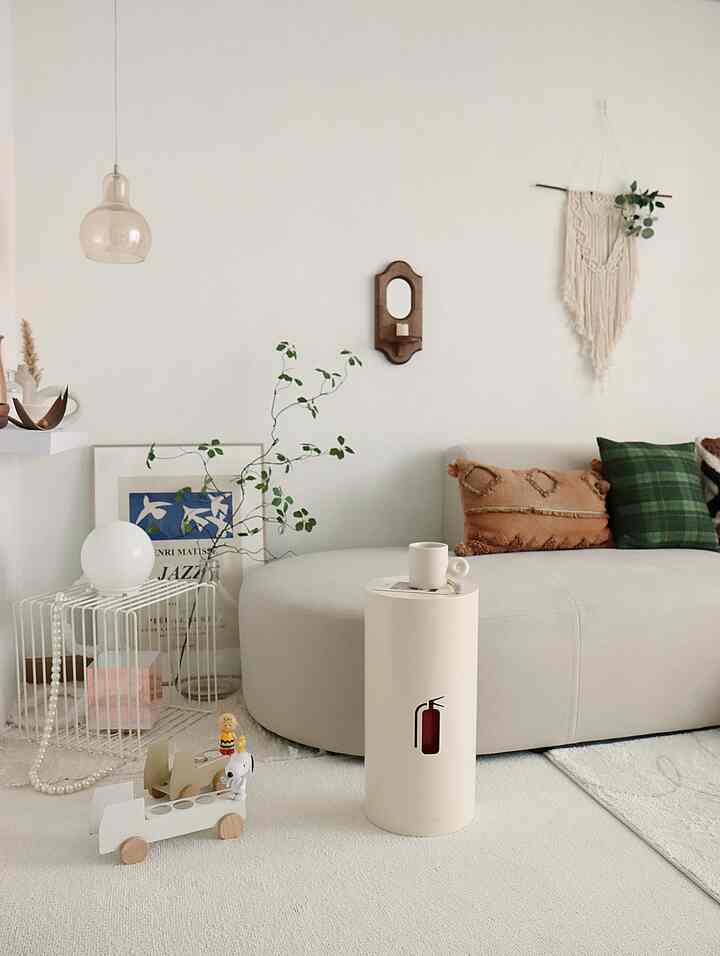 White-toned living room featuring a rounded sofa and simple objets in a cozy setting