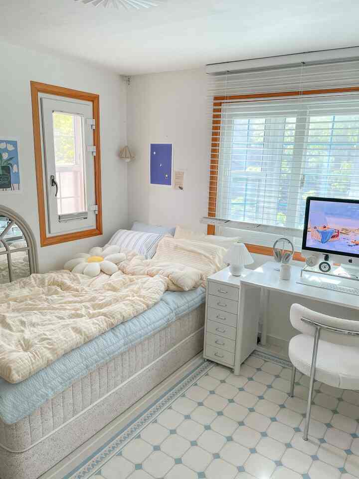 White and wood-toned bedroom featuring a compact desk and office chair, cozy space for a single household