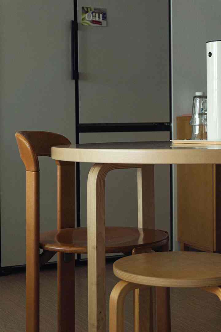 Natural tone kitchen space featuring Artek round table and stools creating a cozy atmosphere