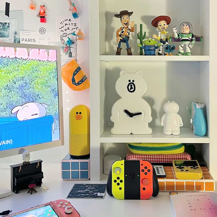 白と黄色のトーンが特徴のミニマルなゲームルーム、ニンテンドースイッチとトイ・ストーリーフィギュアが配置された清潔なデスク空間
