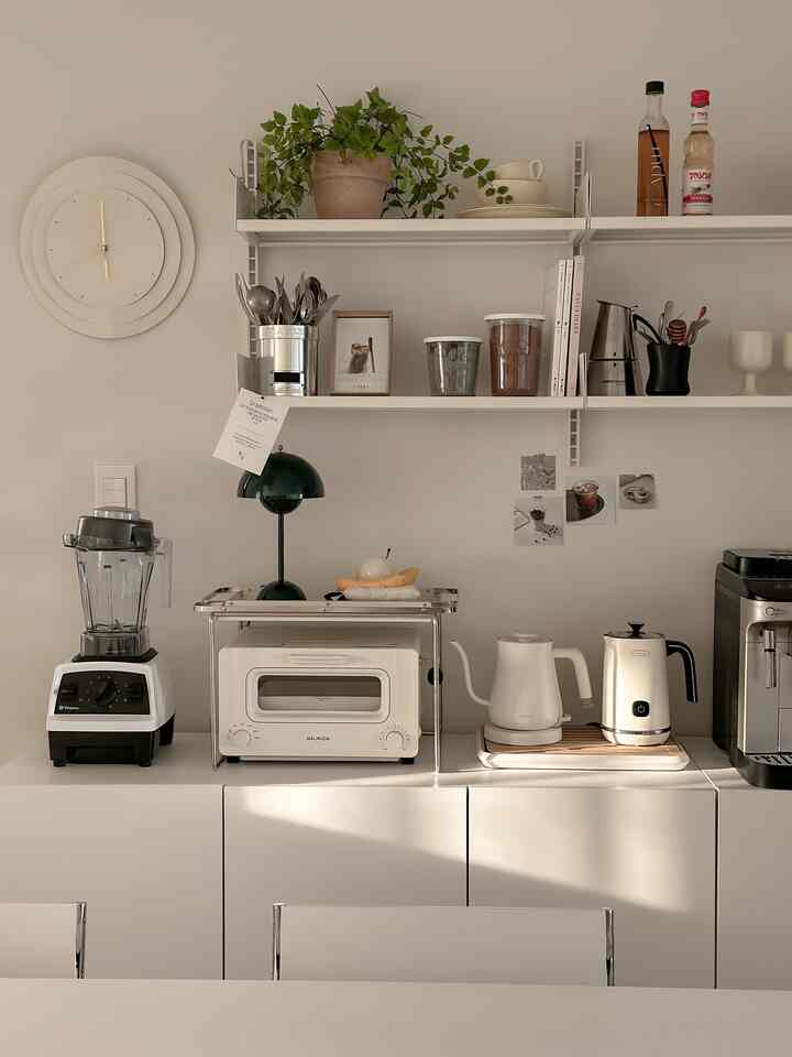 Ivory and white toned kitchen featuring Rarelow wall shelves and neatly arranged kitchen appliances
