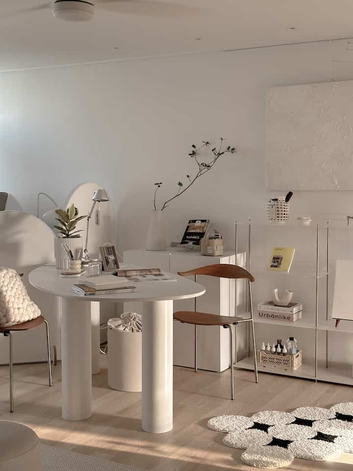 Natural toned living room space featuring transparent shelves and wood-toned chairs with a sleek, cozy atmosphere