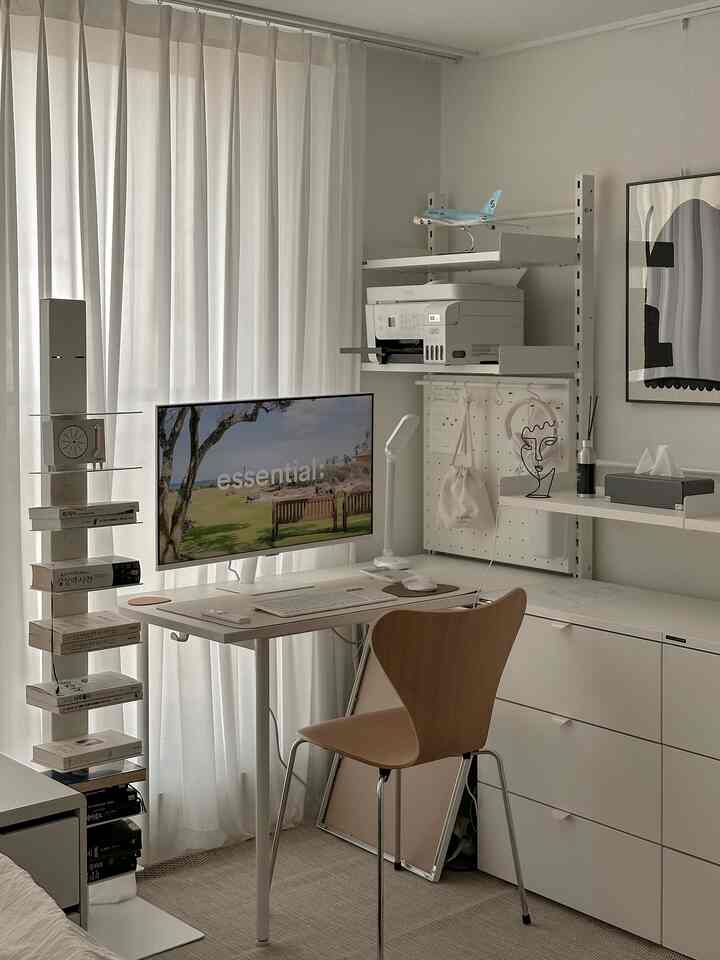 A white and wood-toned study space featuring a bookshelf, Hanssem Plot shelves, and a simple desk with chair in a clean home office interior