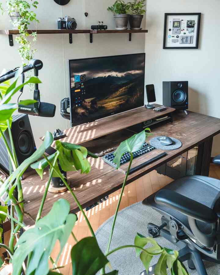 Warm wood tones and beige background in a home office desk space featuring plants with a cozy atmosphere