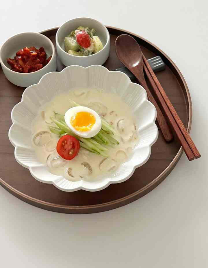 木目調のトレイに花形の白い器と木製の箸が置かれた清潔感のあるテーブルセッティング