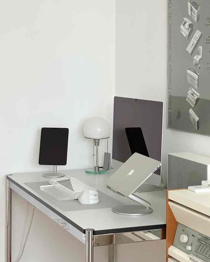 White and gray toned compact home office study featuring Apple computers and Mid-Century Modern furniture