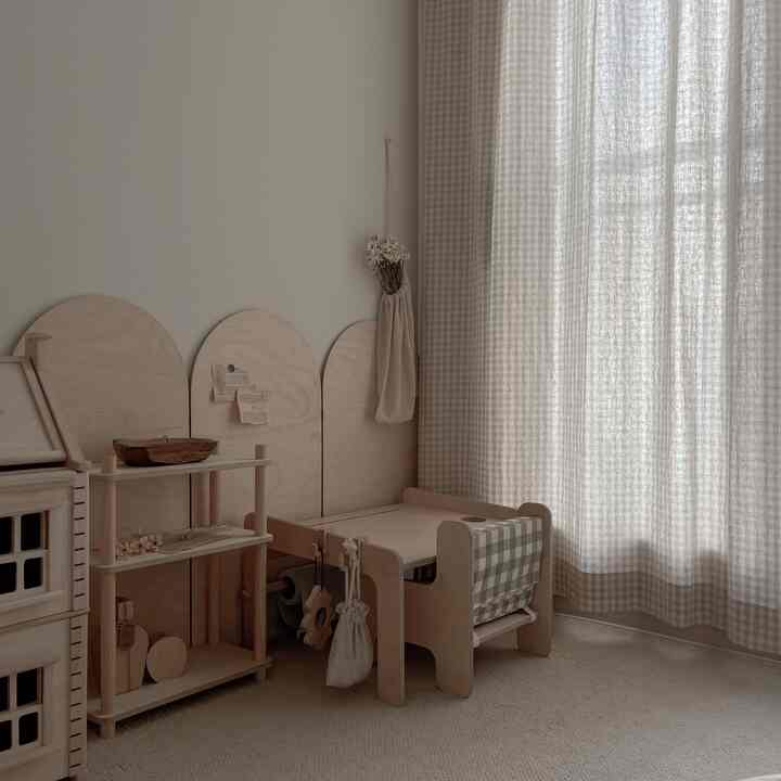 柔らかな木目調とベージュカラーの子供部屋、白樺材のデスクとチェック柄カーテンが配置された落ち着いた雰囲気のあるインテリア