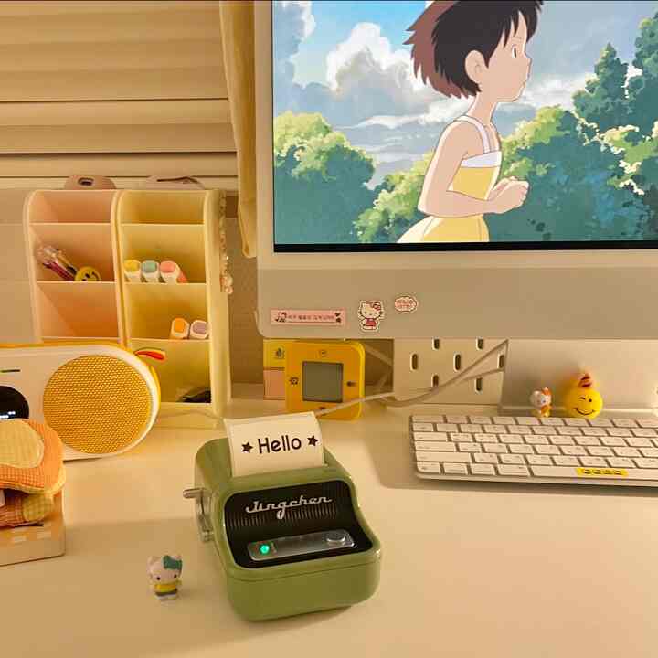 Bright white and yellow toned compact home office featuring a retro label printer and cute stationery on the desk