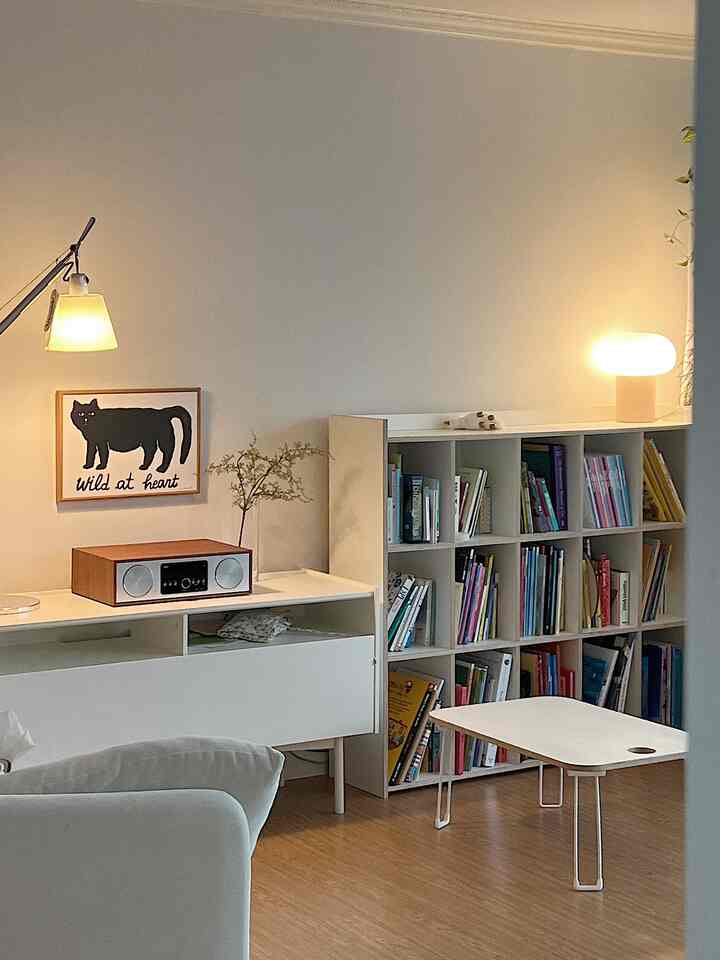White and wood-toned kids' room featuring bookshelf and CD player, bright and cozy atmosphere