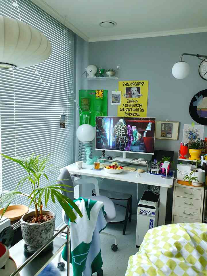 Compact home office space in white and gray tones featuring a sleek desk, office chair, plants, and modern decor with cozy atmosphere