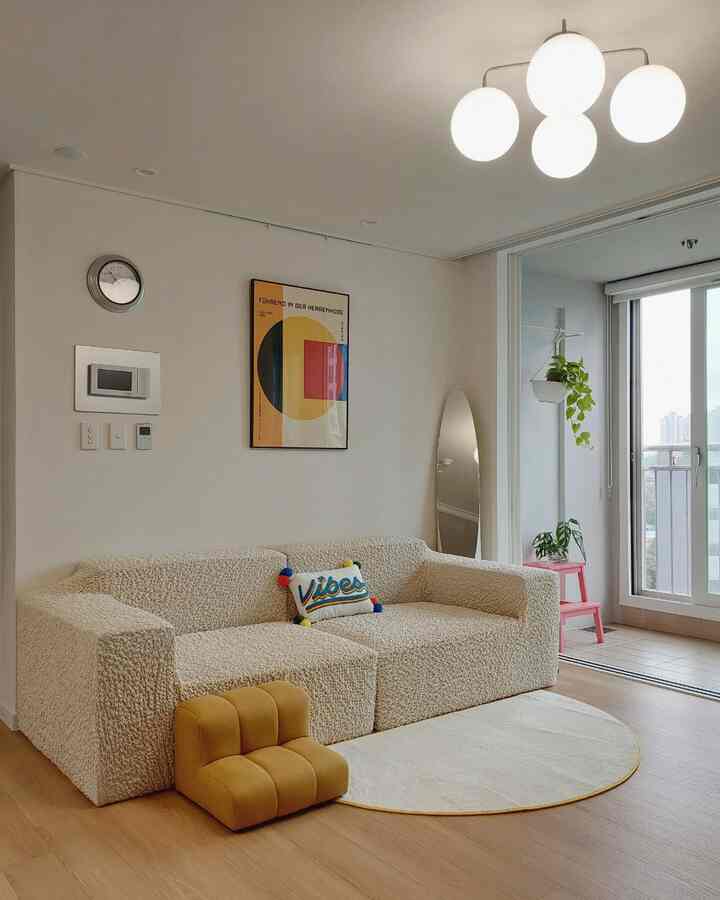 Beige and wood tone living room featuring a beige sofa with pet steps and mid-century modern framed art, cozy ambiance