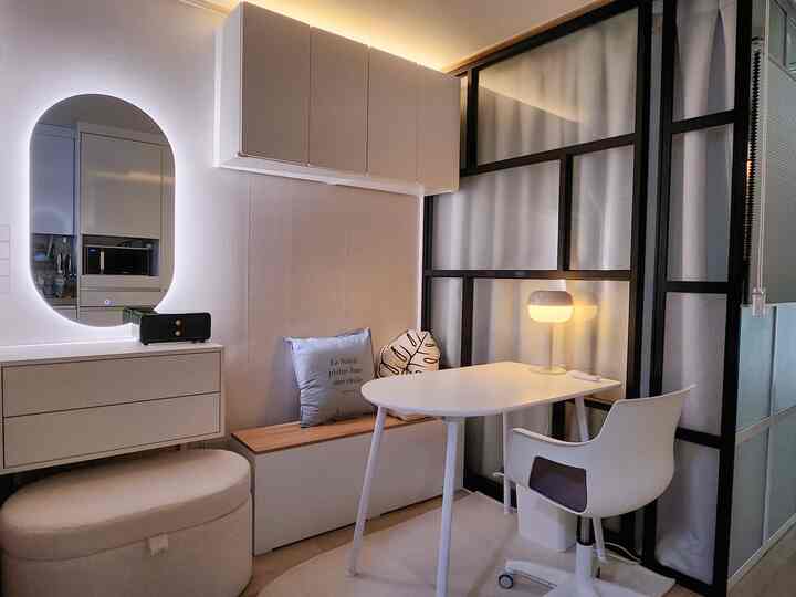 Mini living room in white and wood tones featuring a bench, oval table, and stand lamp creating a cozy atmosphere
