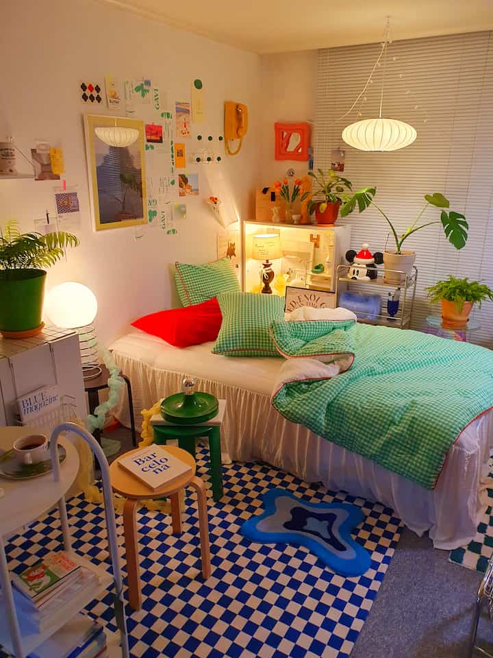 Warm beige bedroom featuring green checkered bedding and a glowing pendant light, creating a cozy atmosphere