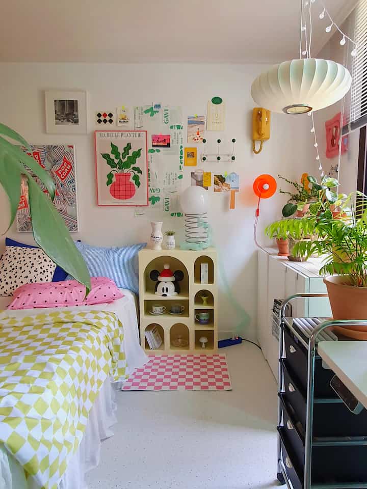 Bright, natural bedroom with white walls and floor, bed, plants, charming wall decor, and ambient pendant lighting