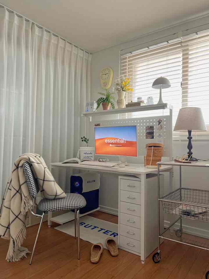 ホワイトとベージュの調和が取れたホームオフィス空間、コンピュータデスクと椅子、棚、照明が配置された清潔感のある作業スペース