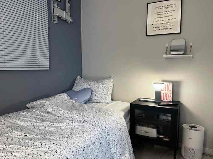 白と黒を基調とした寝室、柄入りの寝具とナイトテーブルが配置されたシンプルでモダンなインテリア