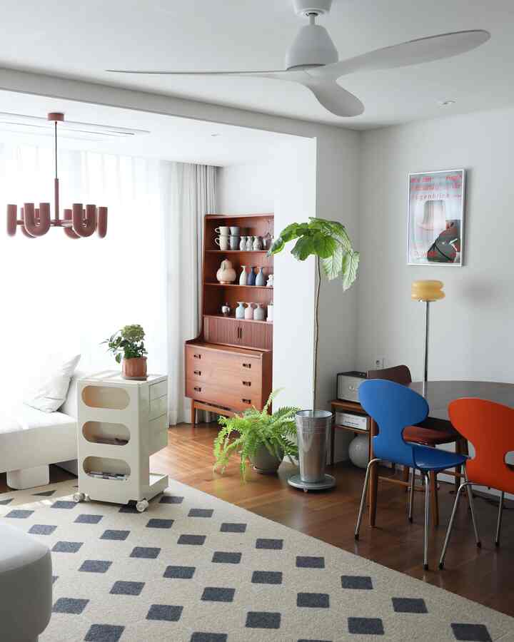 Natural-toned dining and living space in white and brown, featuring plants and soft natural lighting