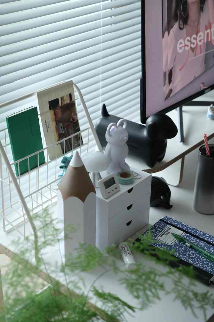 白を基調としたホームオフィス空間、かわいいデスク小物とブラインドが配置された清潔感のあるインテリア