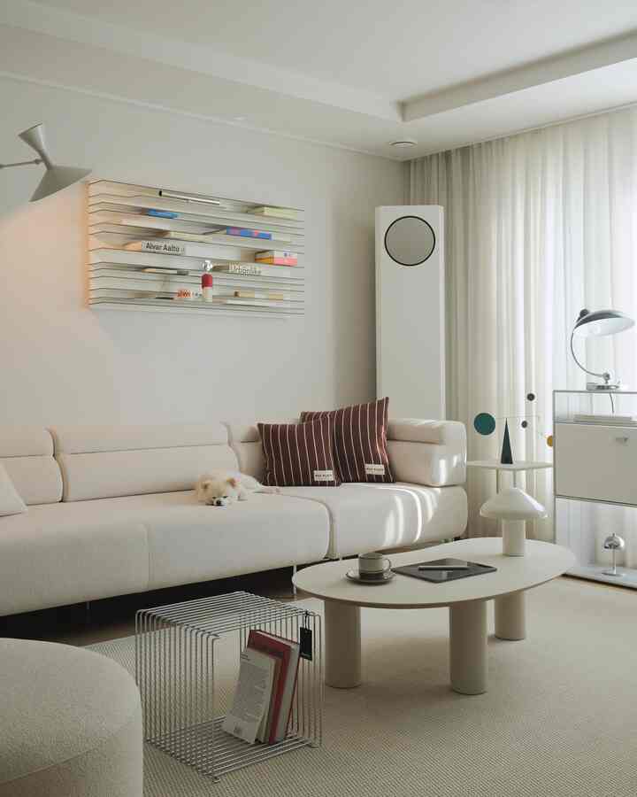 Bright white tone living room featuring a cream sofa with a sleeping dog, muted striped cushions, minimalist table lamp, and natural modern interior