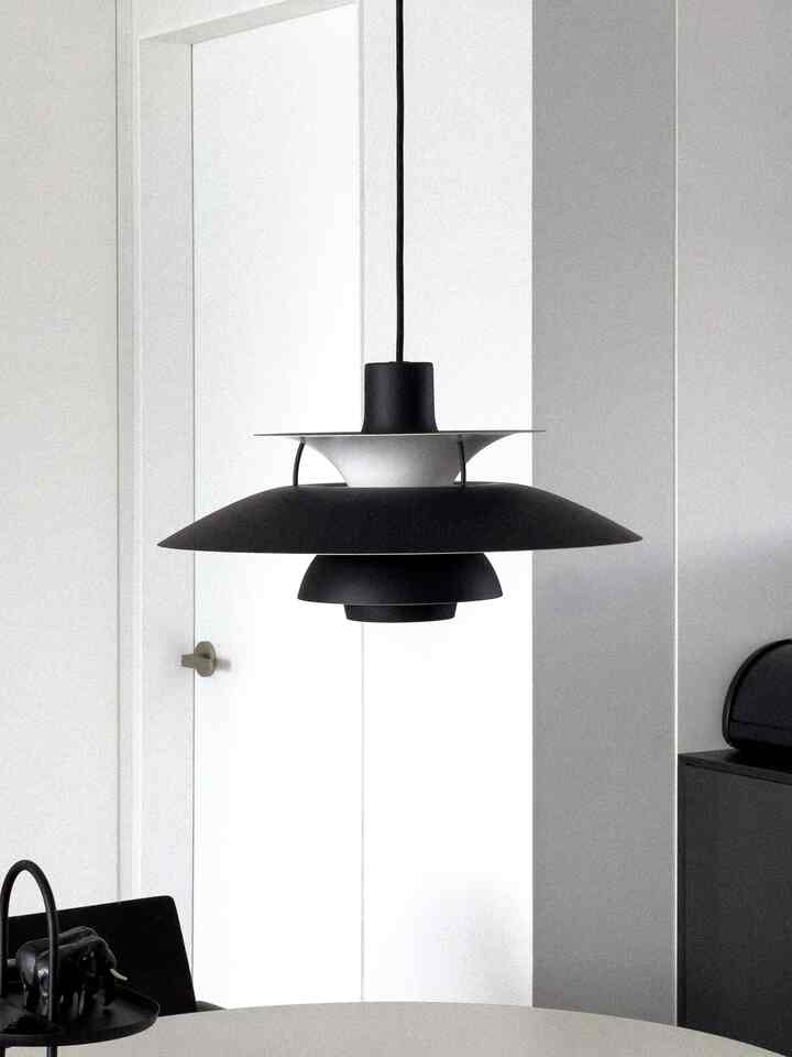 Black tone pendant light featured in a simple and modern dining room space