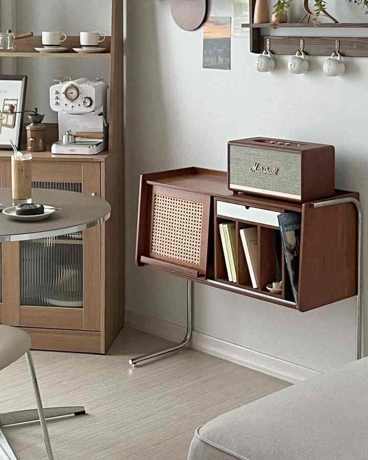 Living room with brown wood tones and white background featuring sliding rattan door cabinet and coffee machine in home cafe setup