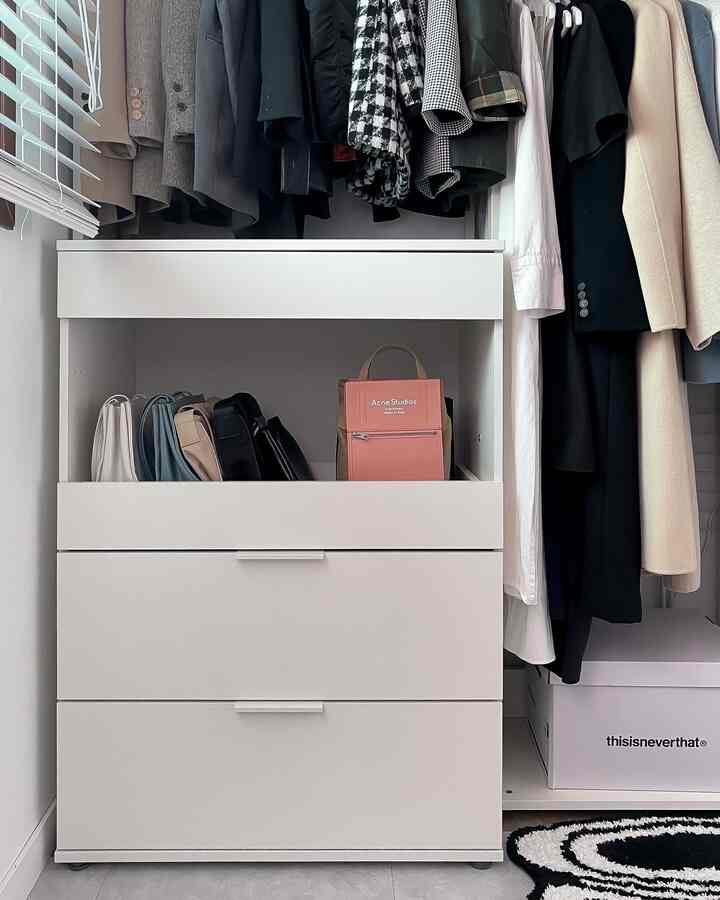 白を基調としたウォークインクローゼット、整頓された収納家具が中央に配置された空間