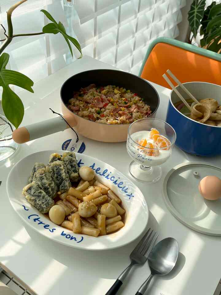 ホワイトとオレンジの色調のベランダのホームカフェ空間、鍋と皿に盛られた感性的なブランチが置かれた自然光のテーブル