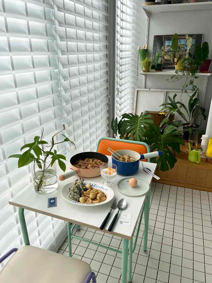 白とミント色調のベランダのおうちカフェ、植物や鍋、皿が配置された落ち着いた雰囲気の空間