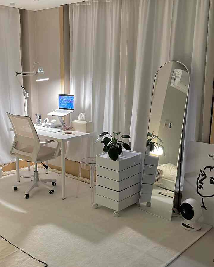 白色のトーンでまとめられたコンパクトなホームオフィス、アーチ型の全身鏡とシンプルな机や椅子が配された清潔感のあるインテリア