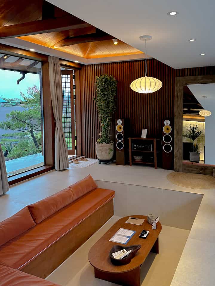 暖かい木目調の韓屋スタイルのリビング、ナチュラルな家具とペンダントライトが調和した空間