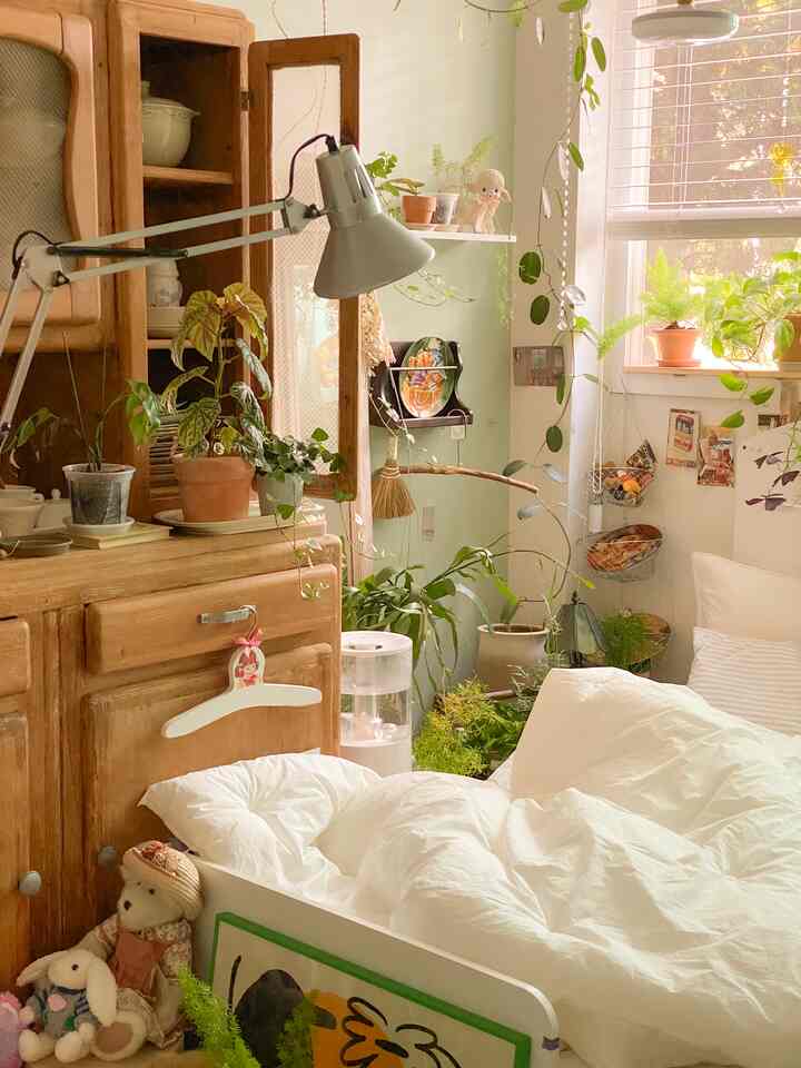 Natural and wood tone bedroom featuring floor lamp and plants with vintage style ambiance