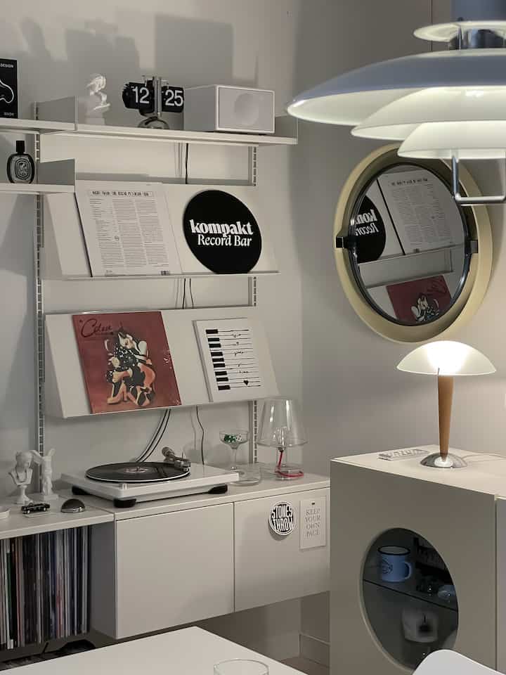 White-toned music listening area featuring vinyl records and vintage turntable in a modern living room setup