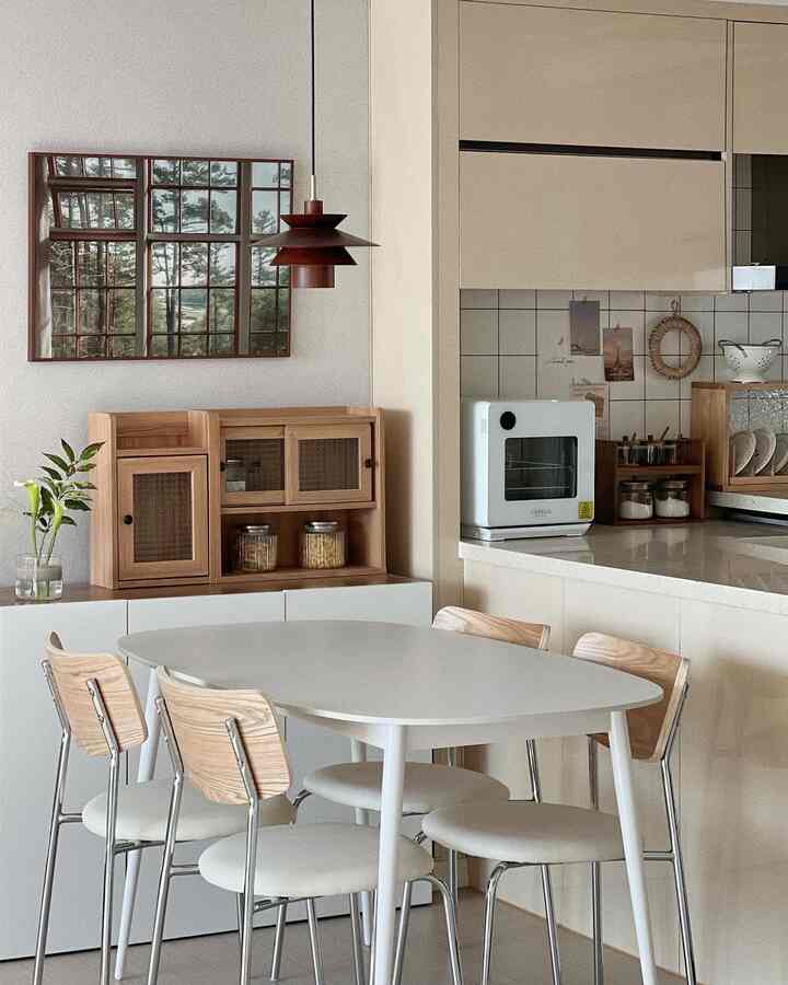 暖かい木目調と白を基調としたダイニングテーブルと椅子が配置されたナチュラルモダンなキッチンの印象的な空間