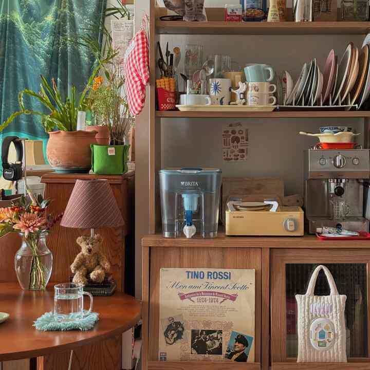 温かみのあるブラウン色調のキッチン、木製家具と植物、コーヒー器具が配置された雰囲気のあるインテリア