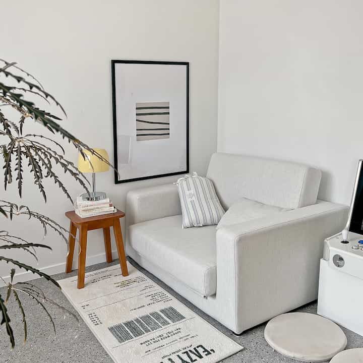 白を基調としたワークスペース、シンプルなソファとレシート柄のカーペットが配置された印象的なインテリア