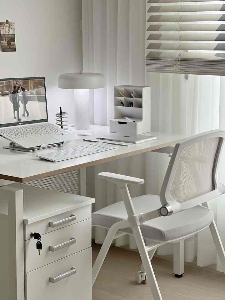 白を基調としたホームオフィス、整然としたデスクとオフィスチェアが配置されたモダンな雰囲気のインテリア