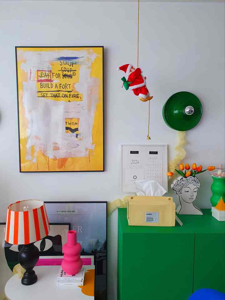 Colorful living room featuring a bright yellow poster, green storage cabinet, orange tulips, and various decorative accessories