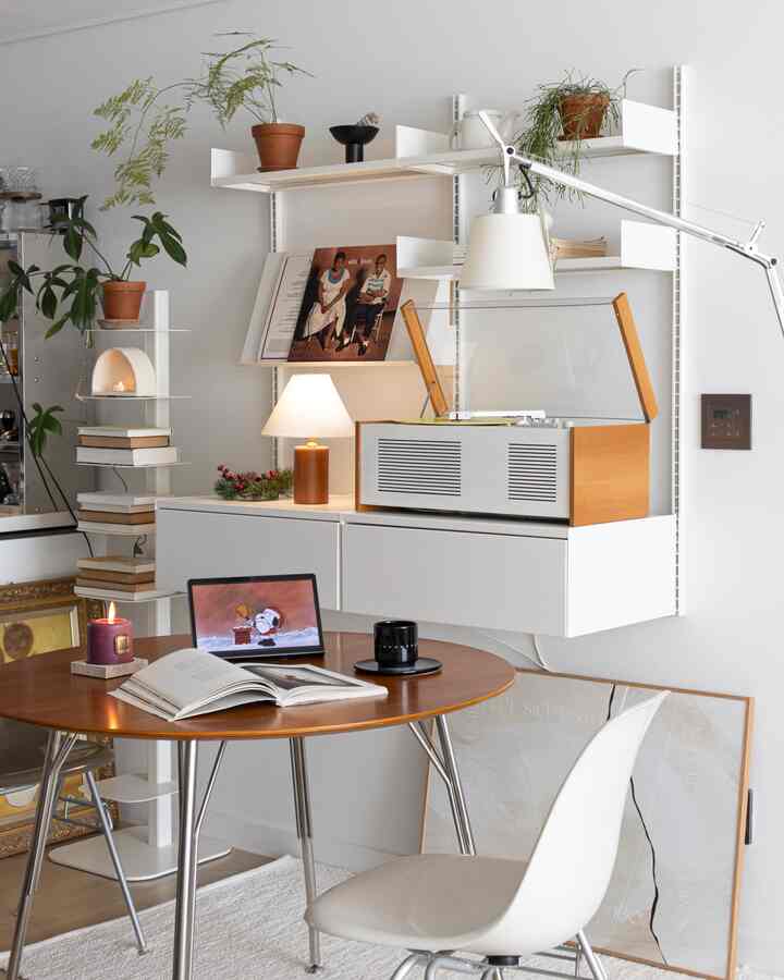 A cozy Nordic space with white walls, wooden table, clean shelves, and ambient lighting